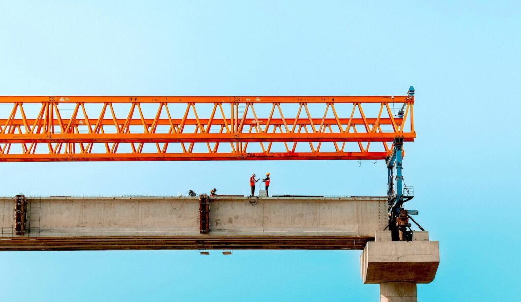 Construction workers at height on a jobsite that requires a comprehensive construction safety plan.